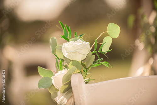 White roses decor on white chairs wedding isle ceremony outdoors