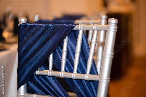 Silver chivari chairs draped in blue silk at wedding reception ceremony
