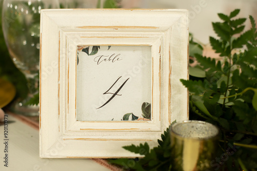 Rustic white picture frame table sign centerpiece with black letters that read 