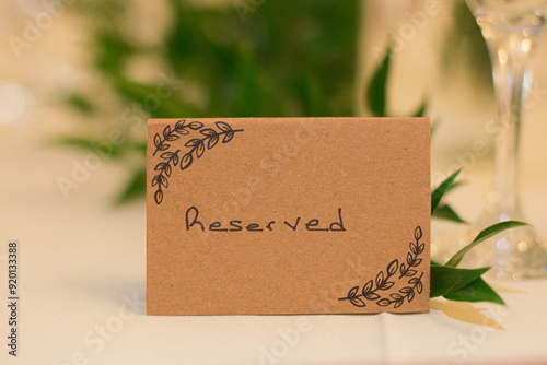 Brown table sign with leaves graphic that reads