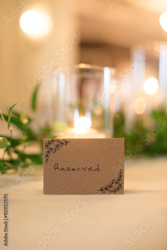 Brown table sign with leaves graphic that reads
