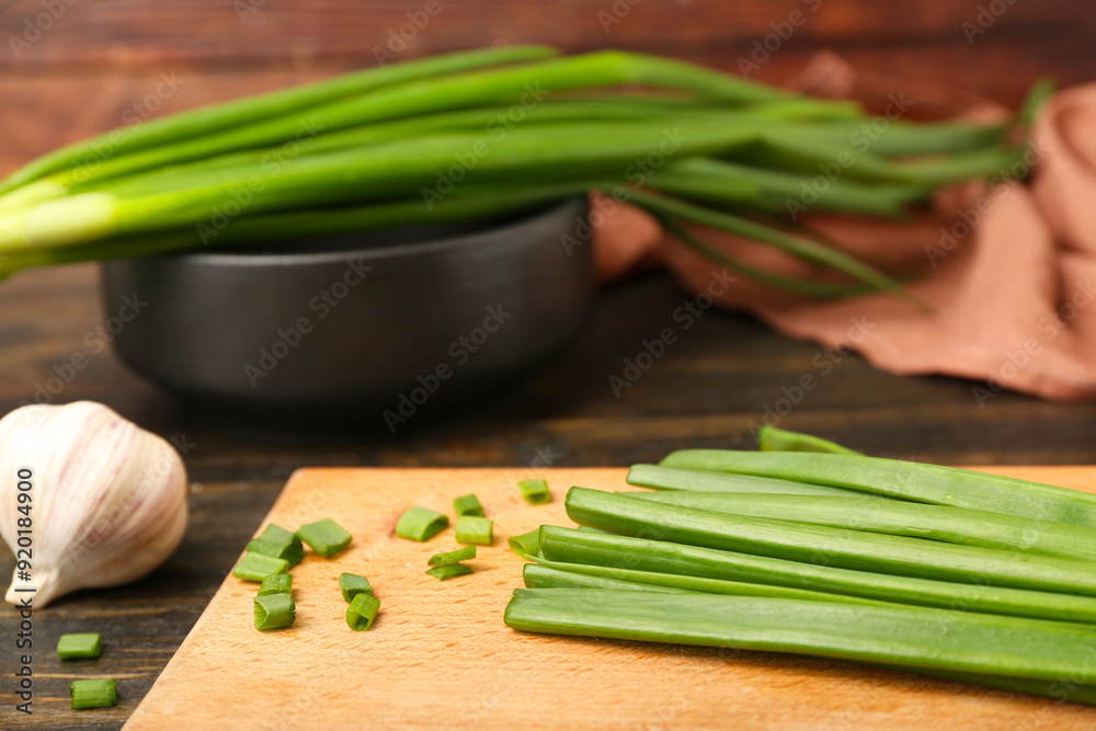 Board with fresh green onion on wooden background Board with fresh green onion on wooden background