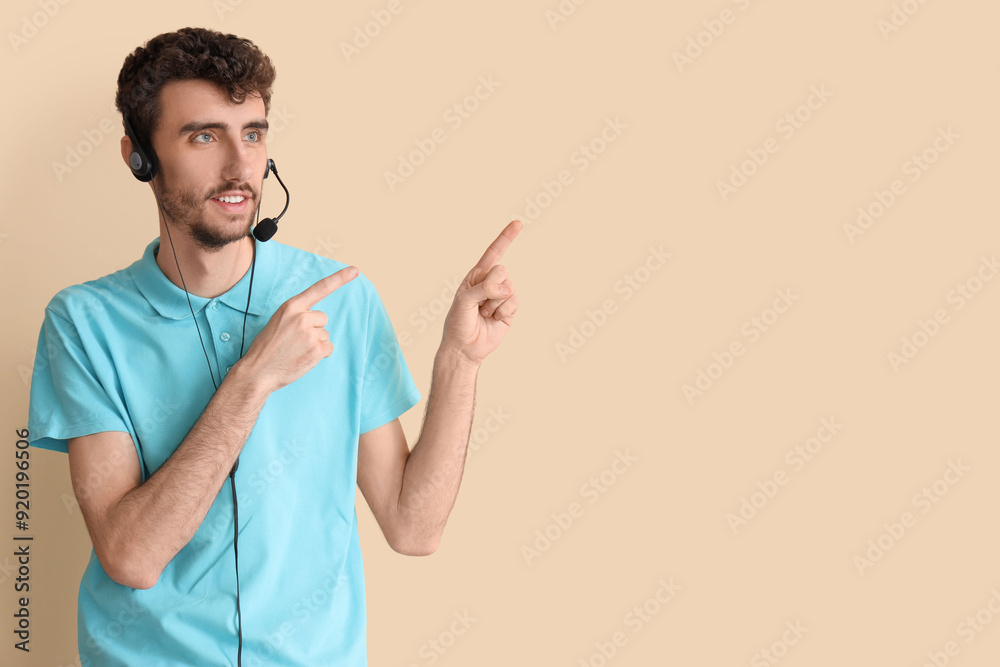 Male technical support agent pointing at something on beige background Male technical support agent pointing at something on beige background