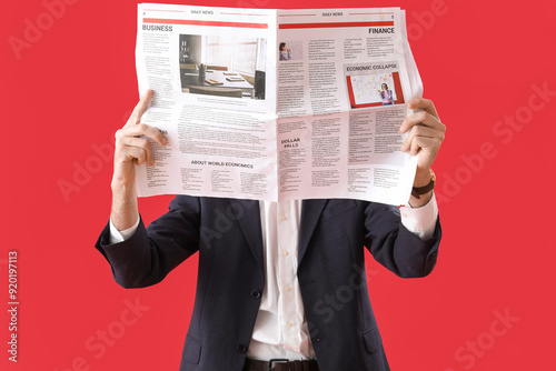 Young man in suit reading n...