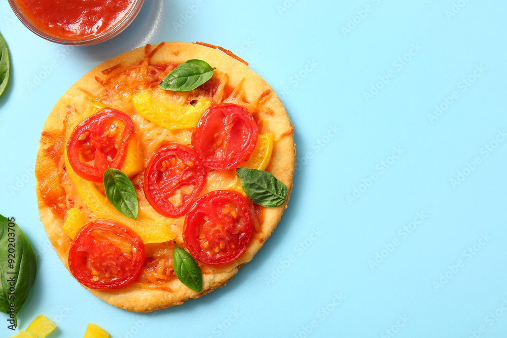 Tasty mini pizza with ketchup on blue background Tasty mini pizza with ketchup on blue background