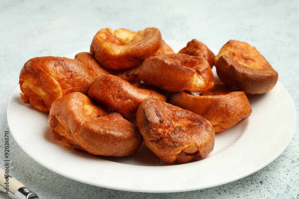 Plate with tasty Yorkshire pudding on light background Plate with tasty Yorkshire pudding on light background