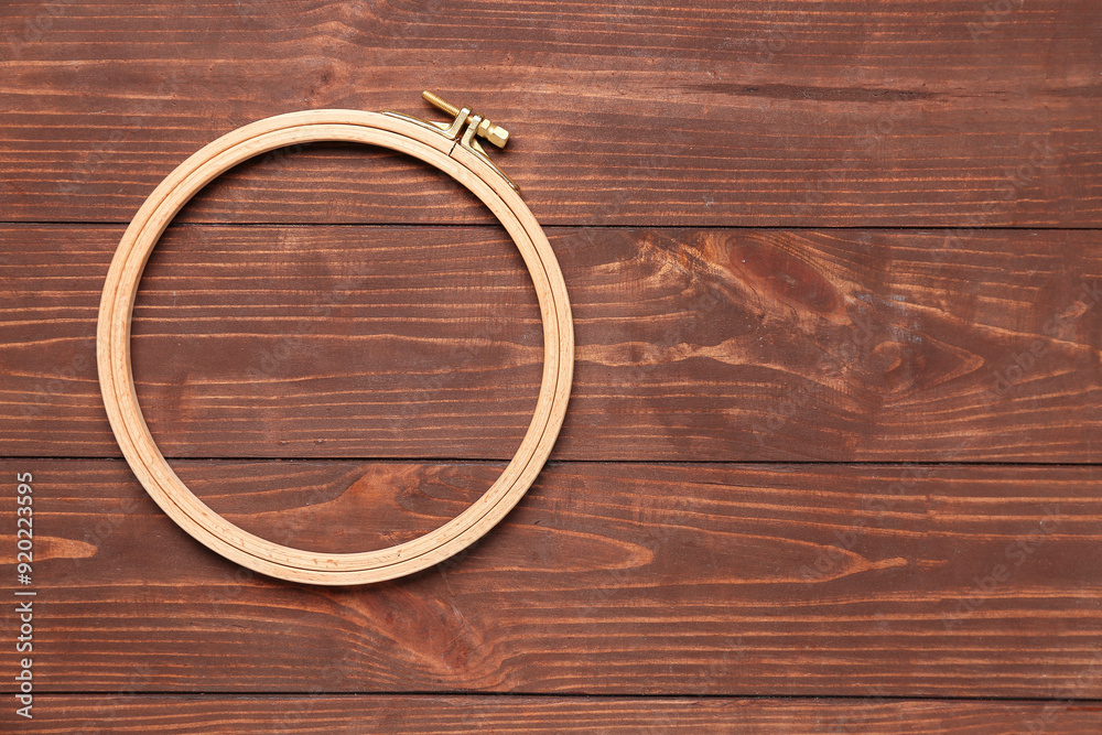Embroidery hoops on brown wooden background Embroidery hoops on brown wooden background