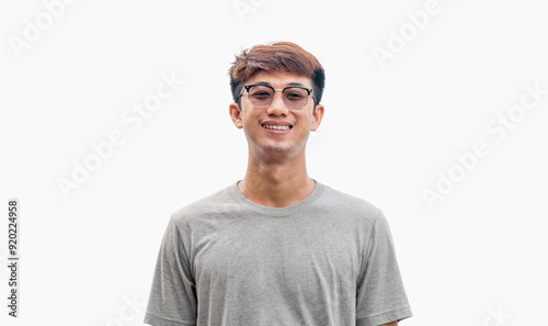 Young man in gray t-shirt smiling happily isolated on gray background