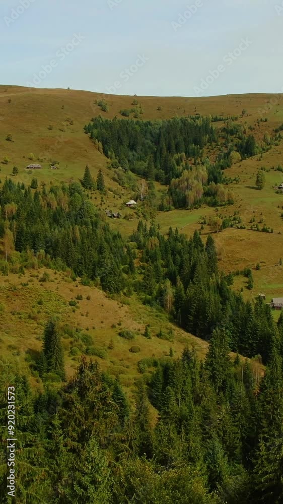 Aerial drone view of mountains and forest trees in clouds. Panoramic nature landscape of mountain peak in fog. Mountain valley with old houses in summer. Aerial drone view of mountains and forest trees in clouds. Panoramic nature landscape of mountain peak in fog. Mountain valley with old houses in summer.