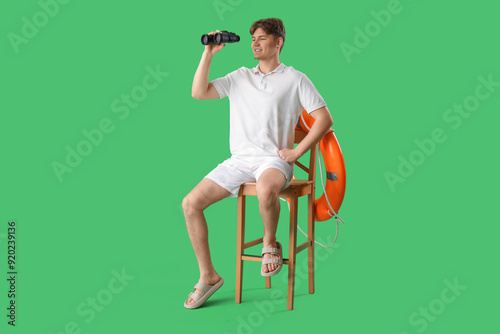 Male lifeguard with binocul...