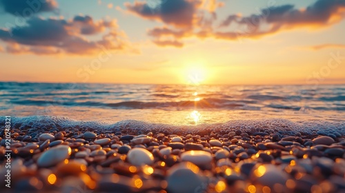 A serene sunset over a tranquil sea, with gentle waves lapping against a shore of smooth pebbles, creating a peaceful atmosphere.