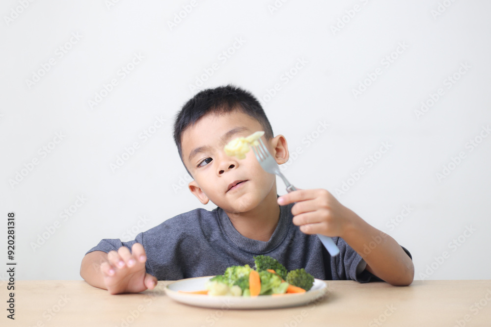 Nutrition healthy eating habits for kids concept. Children do not like to eat vegetables. Little cute boy refuses to eat healthy vegetables. Nutrition healthy eating habits for kids concept. Children do not like to eat vegetables. Little cute boy refuses to eat healthy vegetables.