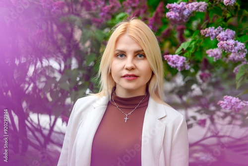 portrait of a young beautiful business woman against the background of blooming lilacs