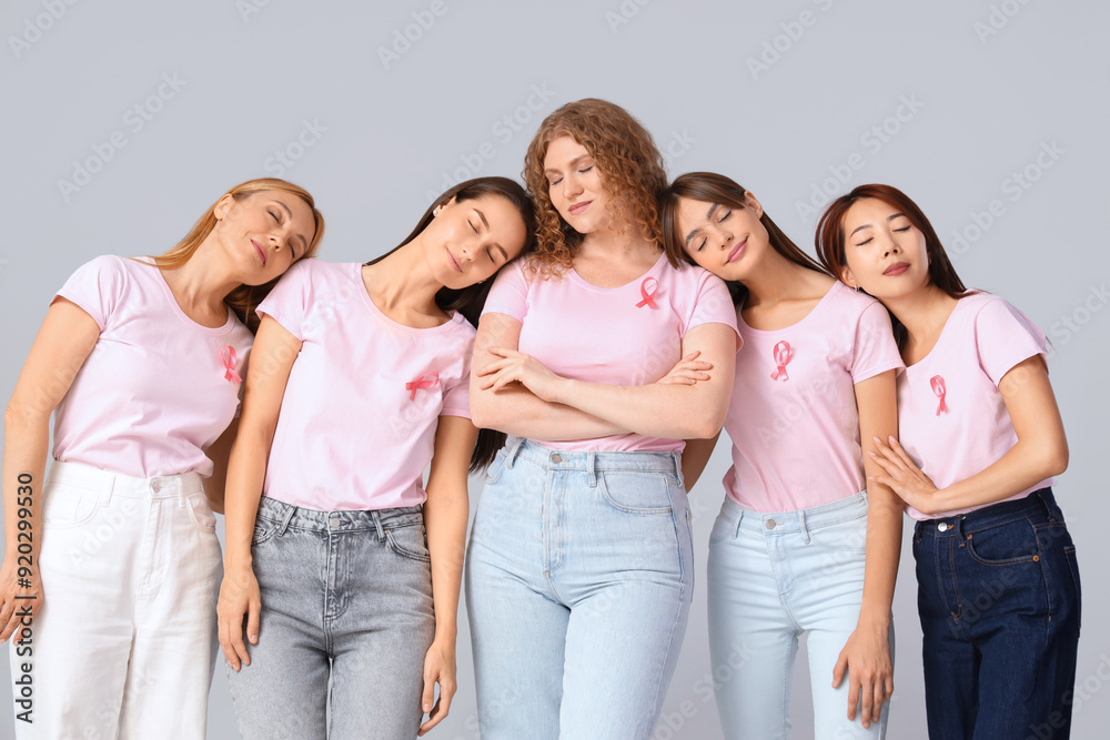 Beautiful women with pink ribbons on light background. Breast cancer awareness concept Beautiful women with pink ribbons on light background. Breast cancer awareness concept