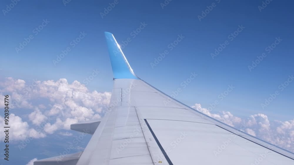 Stunning view from an airplane window featuring the wing and fluffy clouds in the sky. Perfect for travel and aviation themes, showcasing the serene and breathtaking beauty of flying above the clouds. Stunning view from an airplane window featuring the wing and fluffy clouds in the sky. Perfect for travel and aviation themes, showcasing the serene and breathtaking beauty of flying above the clouds.