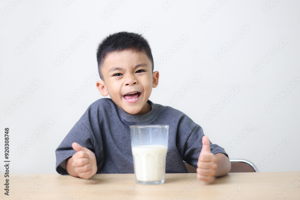 Asian child drinking milk on white background. Smiling of Asian boy with a glass of milk. Asian child drinking milk on white background. Smiling of Asian boy with a glass of milk.
