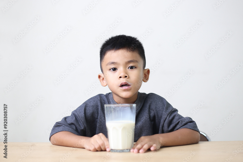 Asian child drinking milk on white background. Smiling of Asian boy with a glass of milk. Asian child drinking milk on white background. Smiling of Asian boy with a glass of milk.