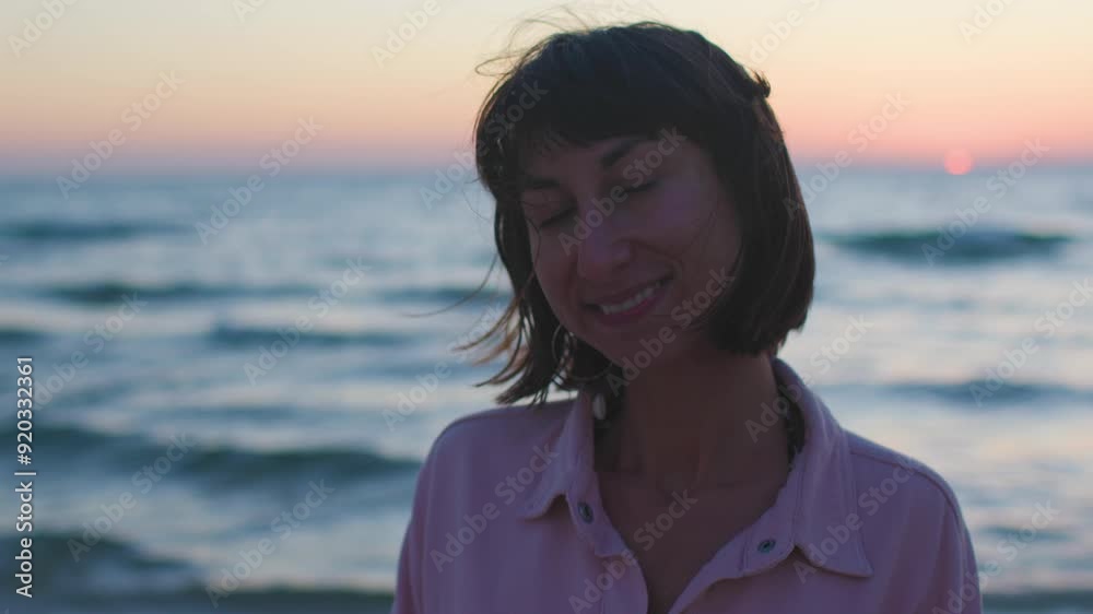 young and cheerful girl posing on the beach in the sunset light. facial hair. Summer tropical mood.