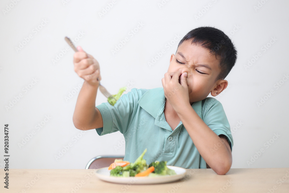 Nutrition healthy eating habits for kids concept. Children do not like to eat vegetables. Little cute boy refuses to eat healthy vegetables. Nutrition healthy eating habits for kids concept. Children do not like to eat vegetables. Little cute boy refuses to eat healthy vegetables.
