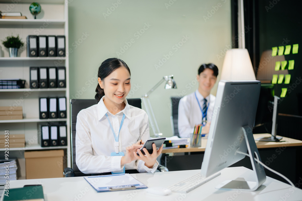 Two young Asian professionals engaged in teamwork and business discussions in modern office embodying corporate Two young Asian professionals engaged in teamwork and business discussions in modern office embodying corporate