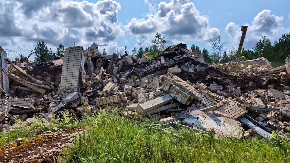 Rubble of a demolished building under a bright blue sky with fluffy clouds and green grass Rubble of a demolished building under a bright blue sky with fluffy clouds and green grass