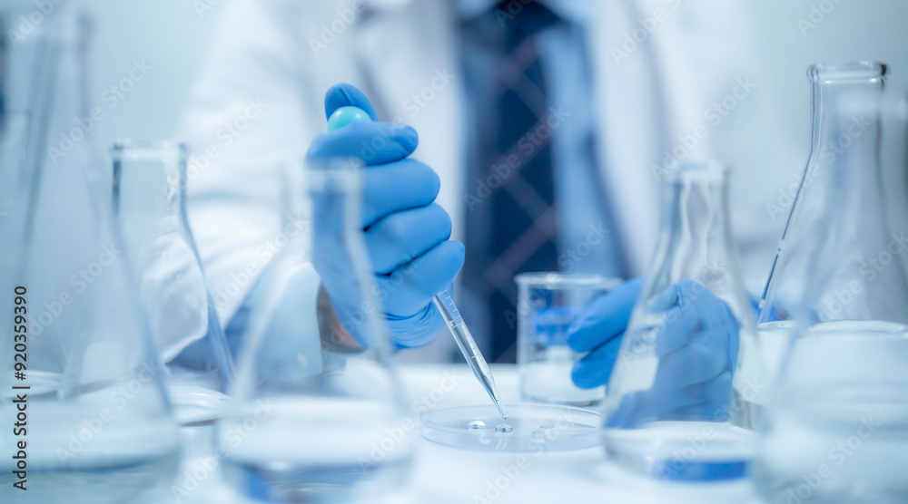 Scientist analyzing and dropping a sample into a glassware, experiments containing chemical liquid in laboratory on glassware Scientist analyzing and dropping a sample into a glassware, experiments containing chemical liquid in laboratory on glassware