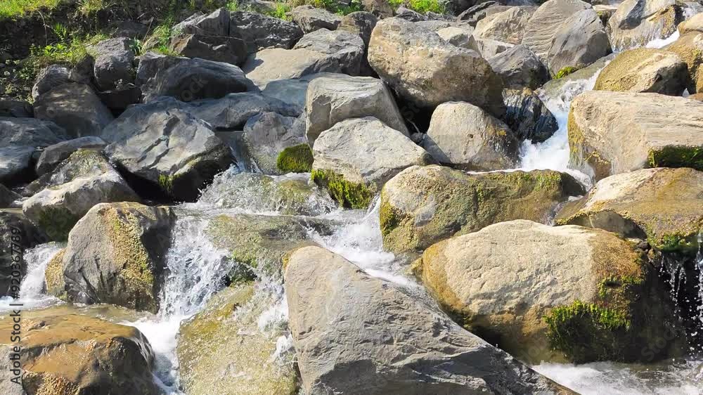 Static shot of water flowing between stones. Mountain stream in sunny summer weather. Weesen, Walensee, Glarus, Switzerland Static shot of water flowing between stones. Mountain stream in sunny summer weather. Weesen, Walensee, Glarus, Switzerland