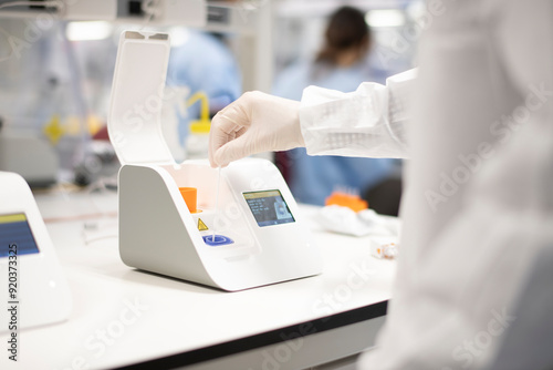 Lab technician placing swab into point-of-care testing machine f