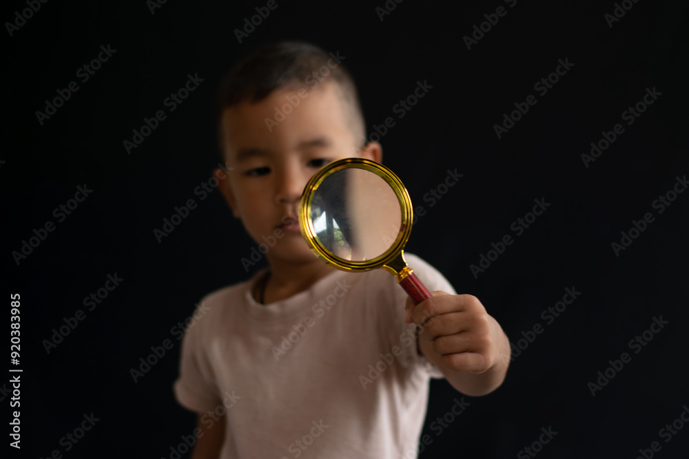 Children use magnifying glasses. The cute little boy looks through the magnifying glass. Children use magnifying glasses. The cute little boy looks through the magnifying glass.