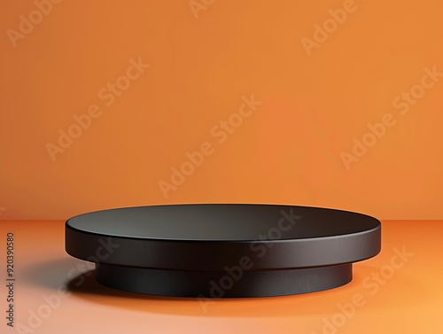 Black podium with a matte finish, positioned on a gradient orange background, text-friendly left side. photo