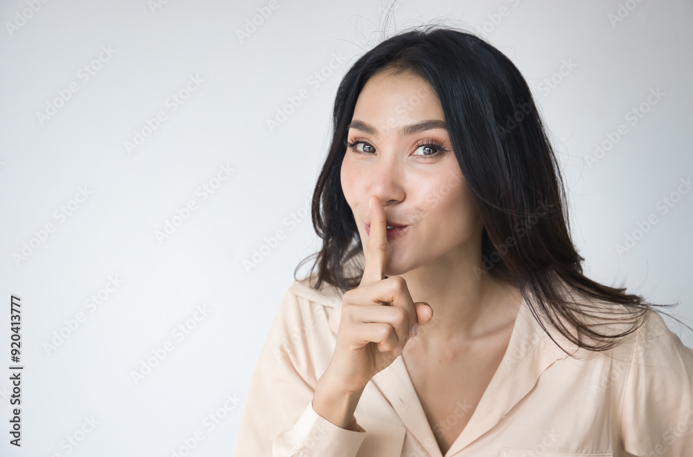 Asian woman asking for your cooperation to keep silent, make no noise with smiling happy friendly expression Asian woman asking for your cooperation to keep silent, make no noise with smiling happy friendly expression