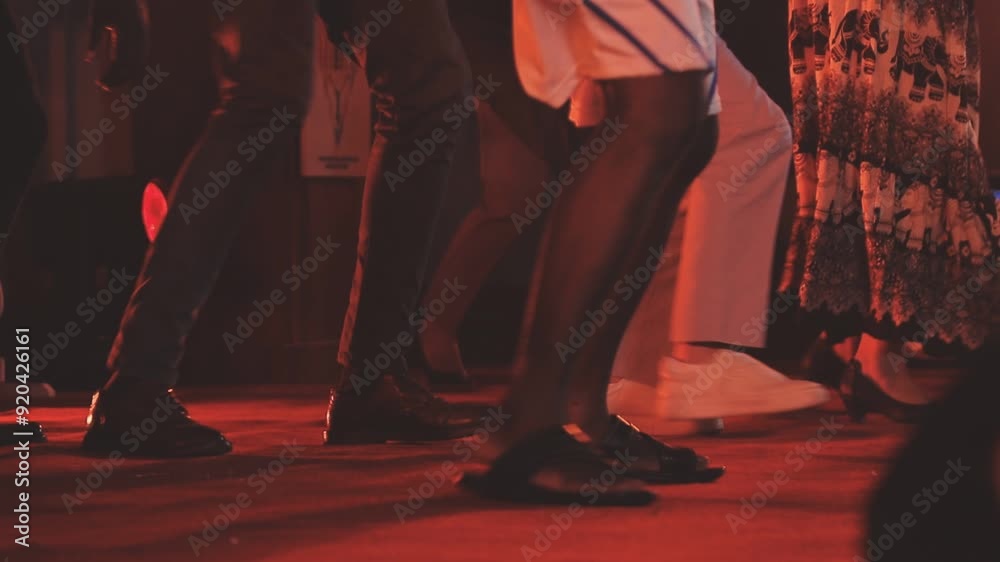 Dancing shoes of a couple, couples dancing traditional latin argentinian dance milonga in the ballroom, tango salsa bachata kizomba lesson, festival on wooden floor, purple, red and violet lights