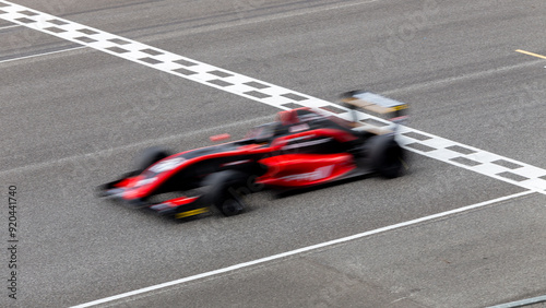 Foto Motion blur race car racing on speed track, Car race on the international circuit race track crossing start and finish line, Race car crossing start and finish line, Target business achieve victory