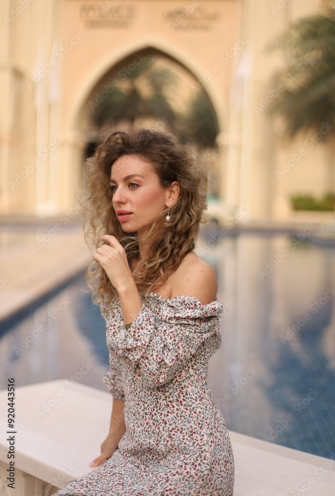 Fototapeta premium portrait of a curly girl against the background of a fountain