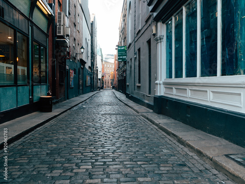 Narrow Cobblestone Street in Urban Center With Historic Buildings During Early Morning Light