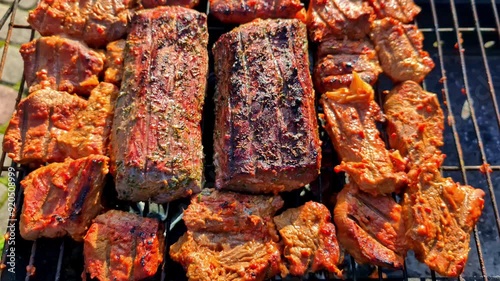 Grilling seasoned meat on the barbeque photo