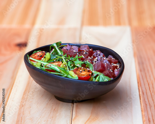 Tuna poke served in a bowl on wooden table. Japanese cuisine photo