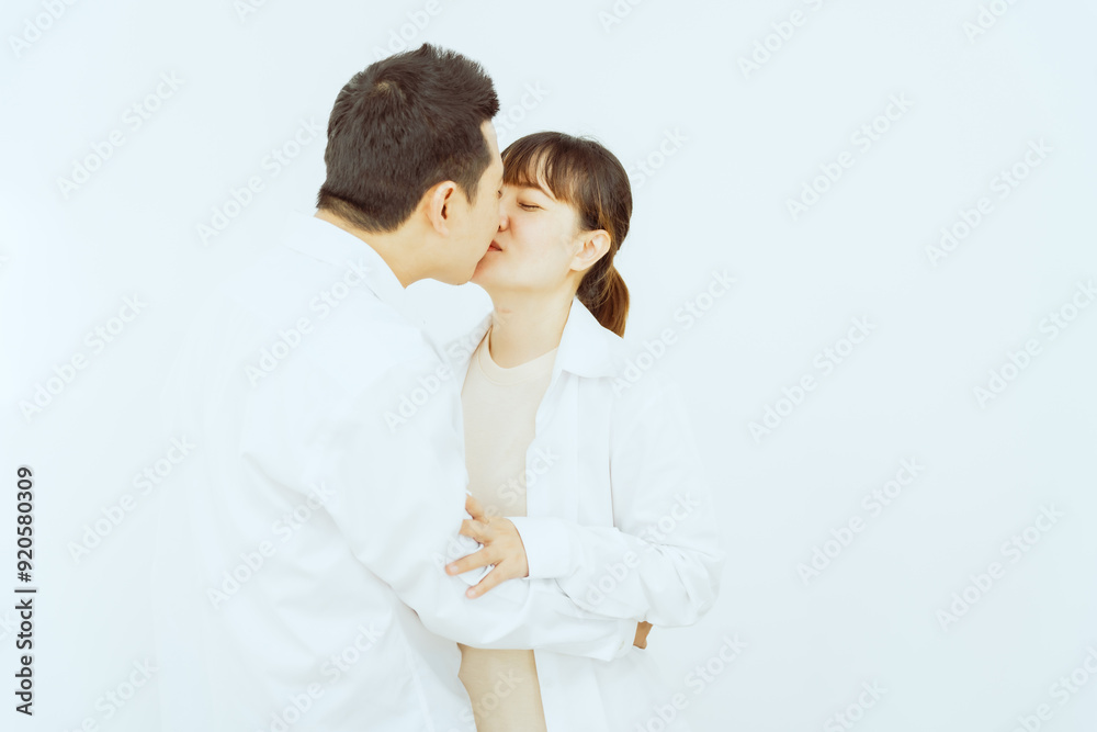 A middle-aged Asian couple, with the woman being pregnant, shares a loving embrace, smiling with happiness and anticipation for their soon-to-arrive baby, symbolizing family togetherness and joy. A middle-aged Asian couple, with the woman being pregnant, shares a loving embrace, smiling with happiness and anticipation for their soon-to-arrive baby, symbolizing family togetherness and joy.