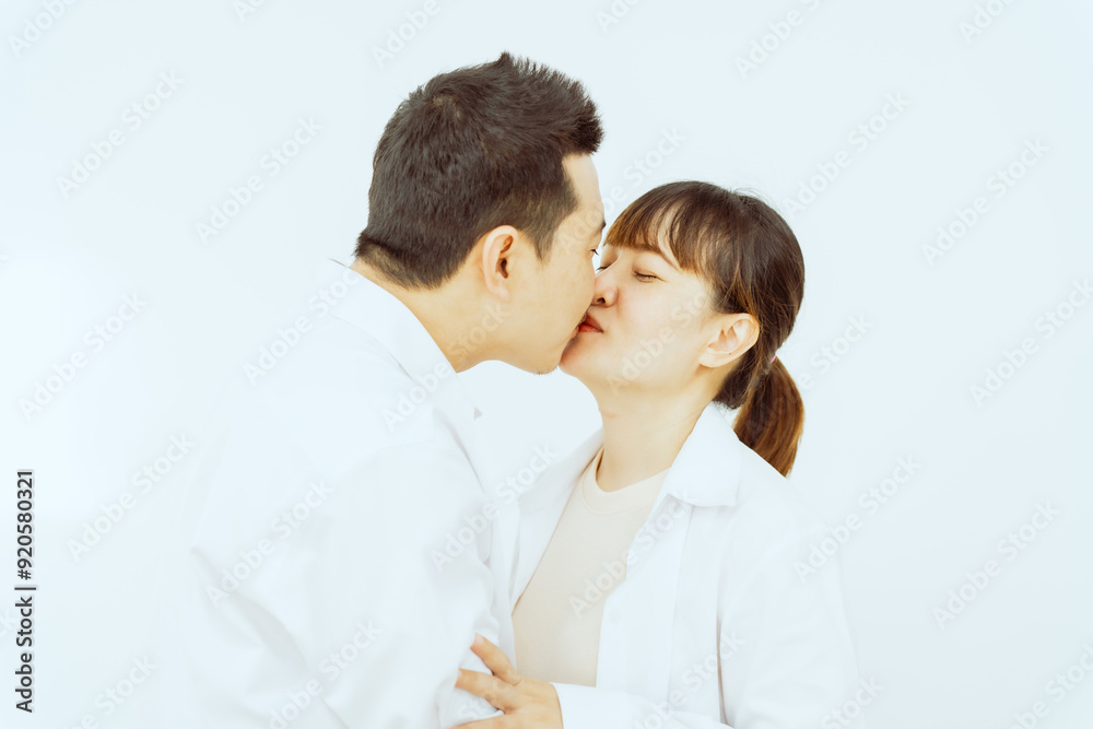 A middle-aged Asian couple, with the woman being pregnant, shares a loving embrace, smiling with happiness and anticipation for their soon-to-arrive baby, symbolizing family togetherness and joy. A middle-aged Asian couple, with the woman being pregnant, shares a loving embrace, smiling with happiness and anticipation for their soon-to-arrive baby, symbolizing family togetherness and joy.