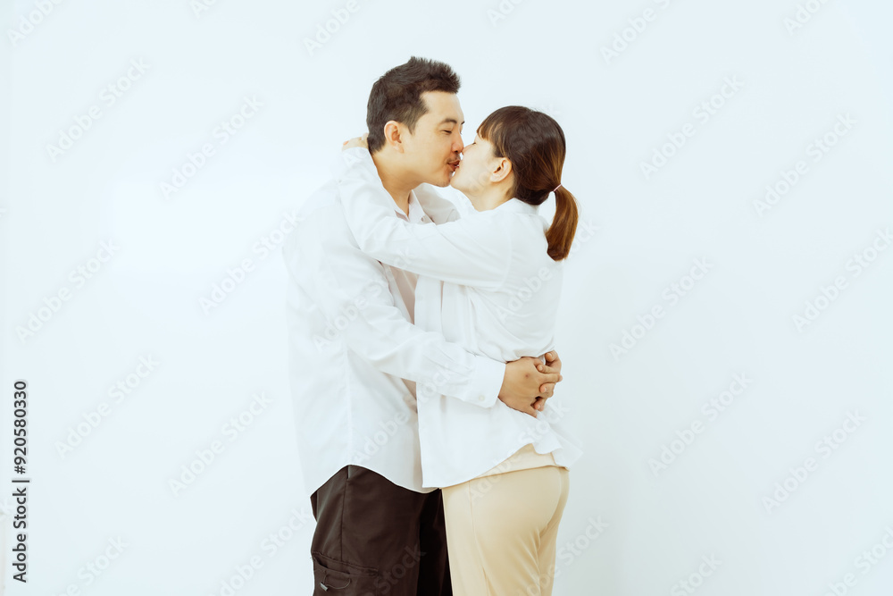 A middle-aged Asian couple, with the woman being pregnant, shares a loving embrace, smiling with happiness and anticipation for their soon-to-arrive baby, symbolizing family togetherness and joy. A middle-aged Asian couple, with the woman being pregnant, shares a loving embrace, smiling with happiness and anticipation for their soon-to-arrive baby, symbolizing family togetherness and joy.