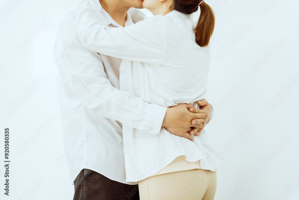 Obraz premium A middle-aged Asian couple, with the woman being pregnant, shares a loving embrace, smiling with happiness and anticipation for their soon-to-arrive baby, symbolizing family togetherness and joy.