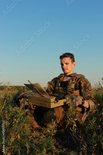 A war correspondent works in the field. citizen journalist with a typewriter. man in military uniform in the forest