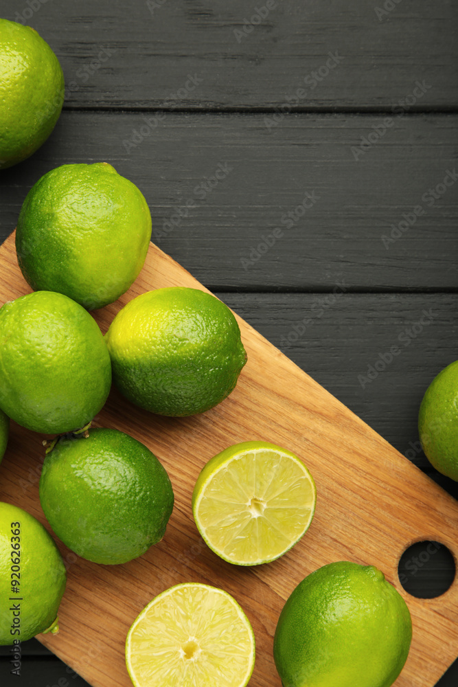 Green lime with cut in half on cutting board on black background. Vertical photo Green lime with cut in half on cutting board on black background. Vertical photo