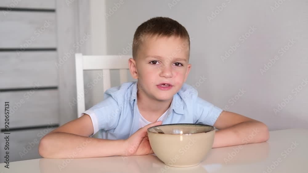 Unhappy child refuses to eat healthy food. Boy doesn't want to eat porridge for breakfast. Proper nutrition, children's menu. Healthy eating. Selective focus. Unhappy child refuses to eat healthy food. Boy doesn't want to eat porridge for breakfast. Proper nutrition, children's menu. Healthy eating. Selective focus.