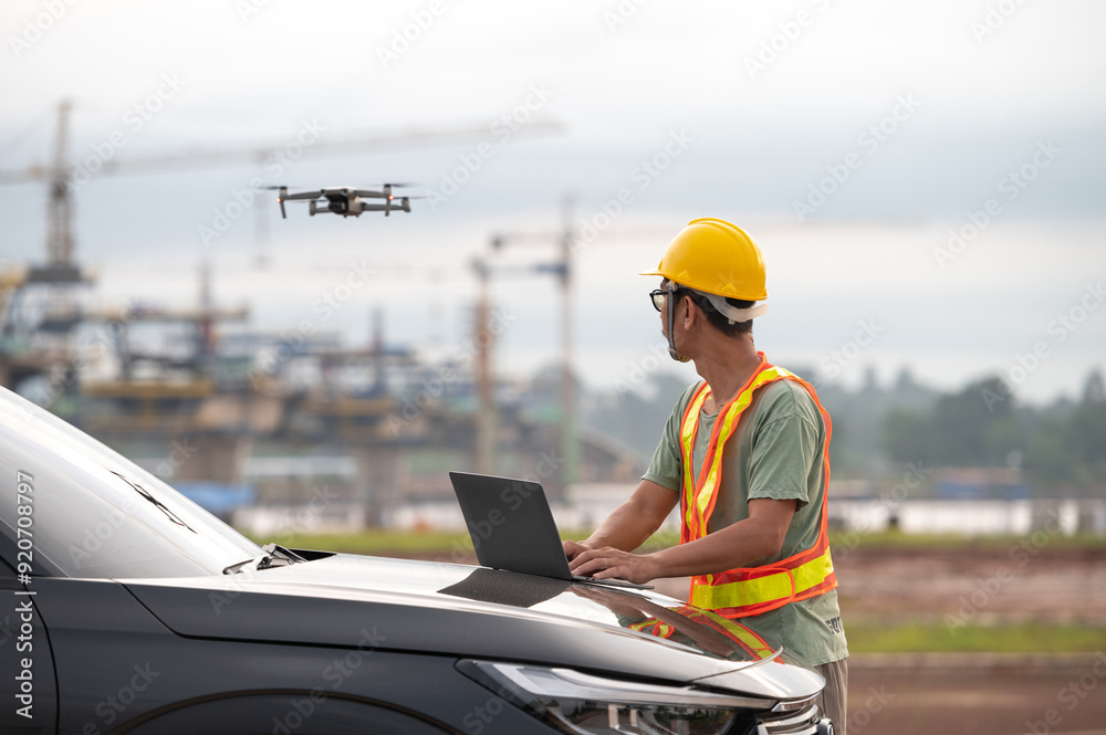 Asian engineers inspect a construction project of a Thailand-Laos Mekong River bridge using a drone to get an aerial view of the bridge. Asian engineers inspect a construction project of a Thailand-Laos Mekong River bridge using a drone to get an aerial view of the bridge.