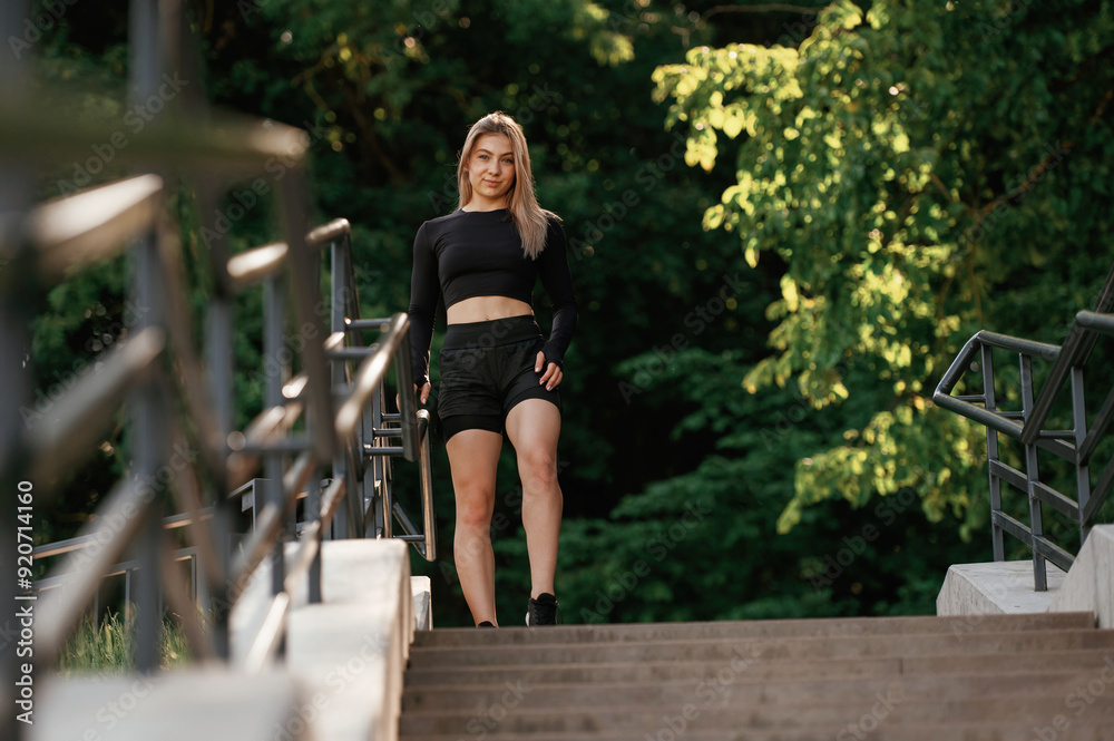 On the bridge with stairs. Beautiful fitness woman in sport clothes is outdoors On the bridge with stairs. Beautiful fitness woman in sport clothes is outdoors