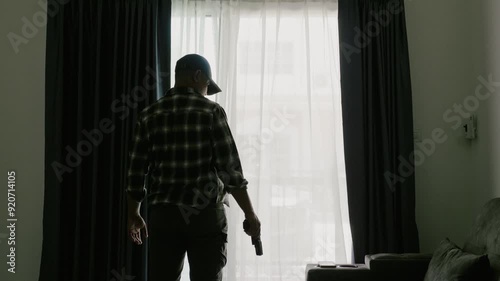 Behind is a man wearing a long-sleeved striped shirt and a cap, holding a gun and looking scary, standing at the entrance of the victim's home.