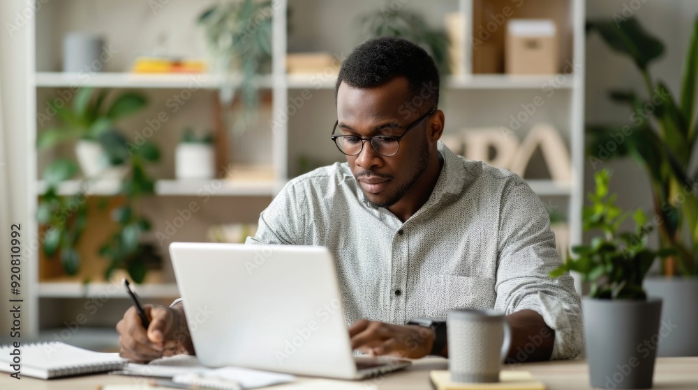 Obraz premium A father sitting at a desk teaching his young son essential life skills like budgeting and financial management using a notebook and calculator in a cozy