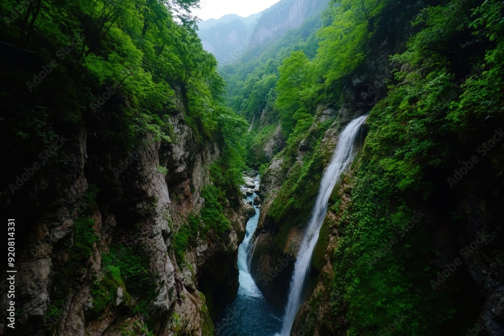 A stunning view of a lush green valley, highlighted by multiple waterfalls cascading into a flowing river below, creating a serene natural landscape with abundant foliage.
