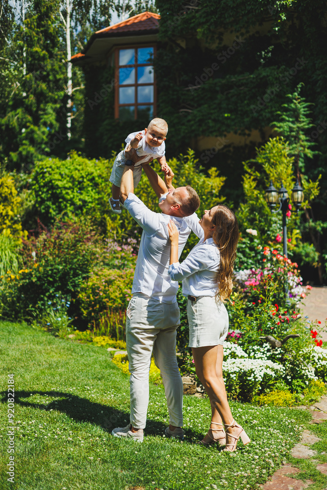 Obraz premium Mom and dad in nature with their one-year-old son. Happy family with little son in nature.